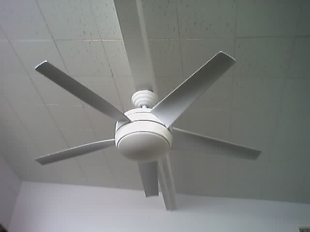 A white fan hanging from a ceiling