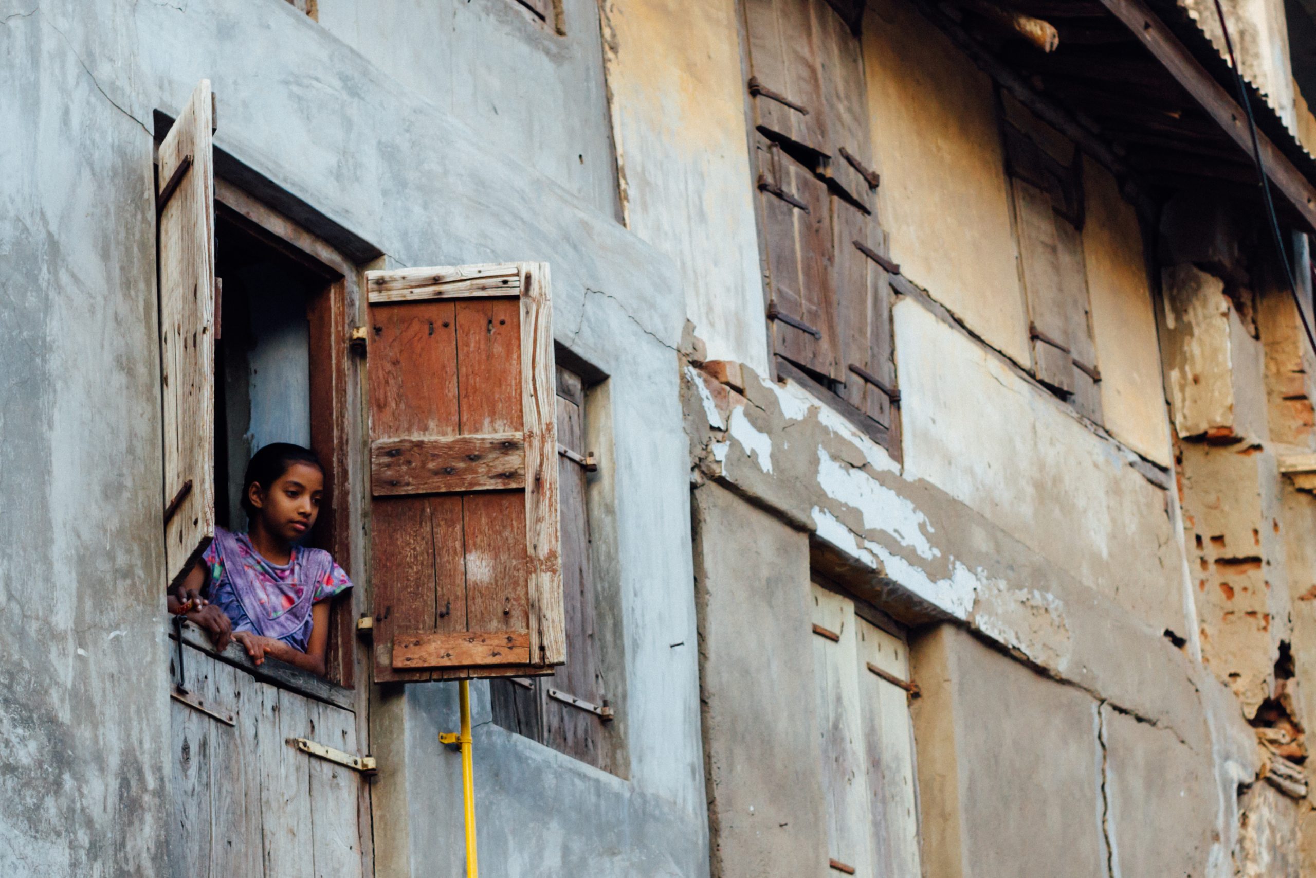 girl looking out from open window
