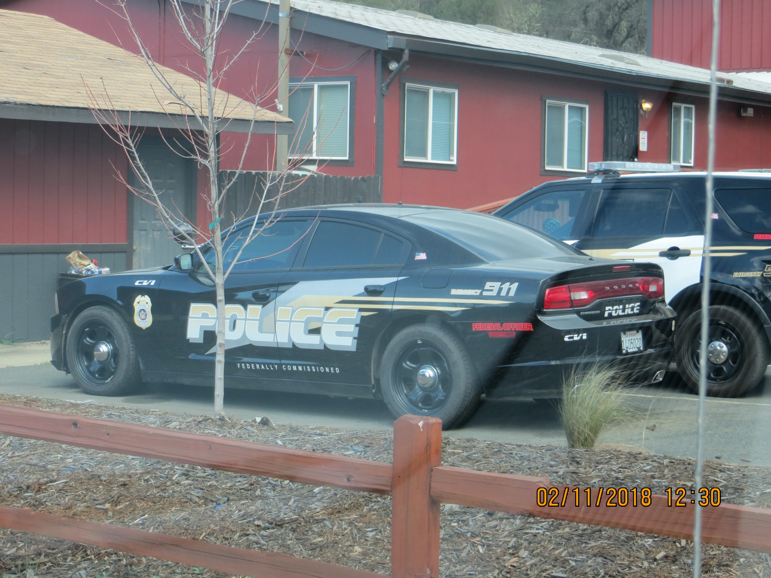 A police station building with two police cars parked outside